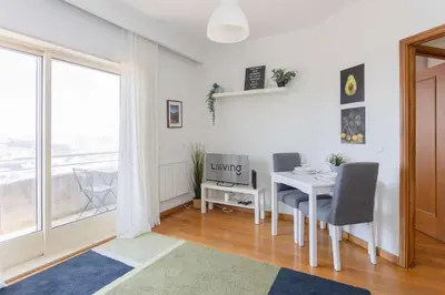 a living room with a table and chairs and a window at Liiiving in Gaia - Douro Balcony View in Vila Nova de Gaia