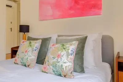 a bed with three pillows and a painting on the wall at Magnolia 5 Luxury with AC Metro Downtown Porto in Porto
