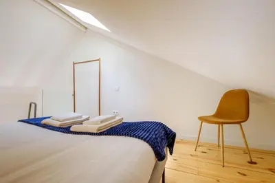 a white room with a bed and a chair at Magnolia 5 Luxury with AC Metro Downtown Porto in Porto