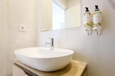 a bathroom with a white sink and a mirror at Magnolia 5 Luxury with AC Metro Downtown Porto in Porto