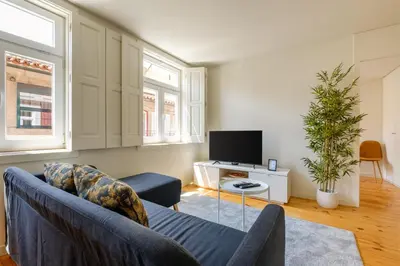 a living room with a couch and a tv at Magnolia 5 Luxury with AC Metro Downtown Porto in Porto