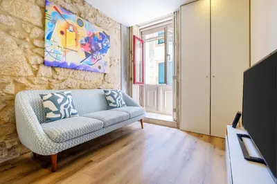 a living room with a couch and a painting on the wall at Magnolia 1 Luxury with AC Metro Downtown Porto in Porto