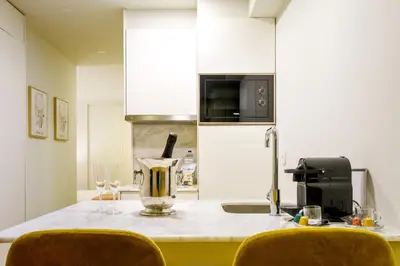 a kitchen with a counter with a blender and two chairs at Magnolia 1 Luxury with AC Metro Downtown Porto in Porto