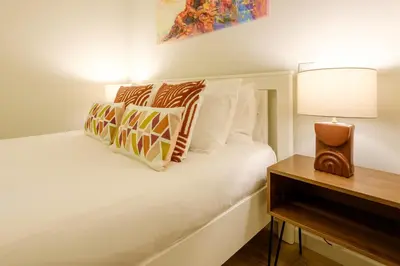 a white bed with pillows and a table with a lamp at Magnolia 1 Luxury with AC Metro Downtown Porto in Porto
