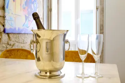 a bottle of champagne in a bucket on a table with two glasses at Magnolia 1 Luxury with AC Metro Downtown Porto in Porto