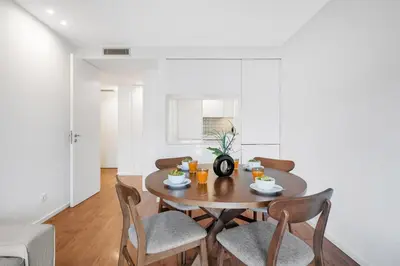 a white bedroom with a large bed and a window at Porto Style & Comfort | Balcony + Parking in Porto