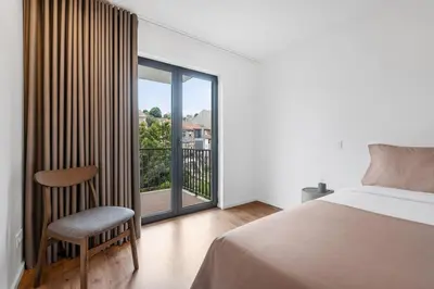 a white kitchen with white cabinets and a sink at Porto Style & Comfort | Balcony + Parking in Porto