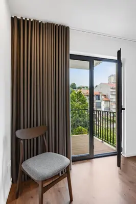 a white kitchen with white cabinets and a sink at Porto Style & Comfort | Balcony + Parking in Porto