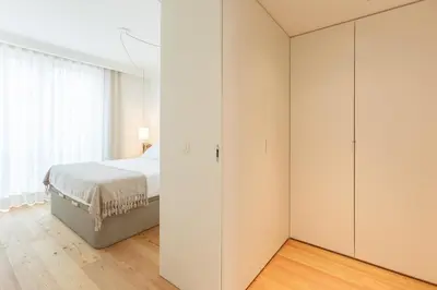 a white bedroom with a bed and a closet at Chic 1-BR Flat in Award-Winning Building in Porto