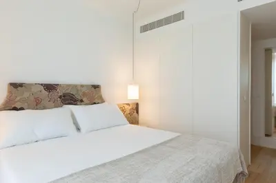 a bedroom with a large white bed with a headboard at Chic 1-BR Flat in Award-Winning Building in Porto