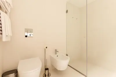 a bathroom with a toilet and a glass shower at Chic 1-BR Flat in Award-Winning Building in Porto