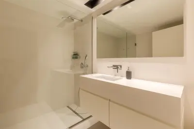 a white bathroom with a sink and a mirror at Chic 1-BR Flat in Award-Winning Building in Porto