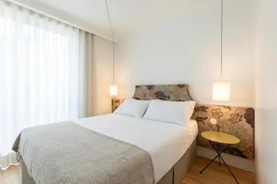 a bedroom with a large bed and a window at Chic 1-BR Flat in Award-Winning Building in Porto