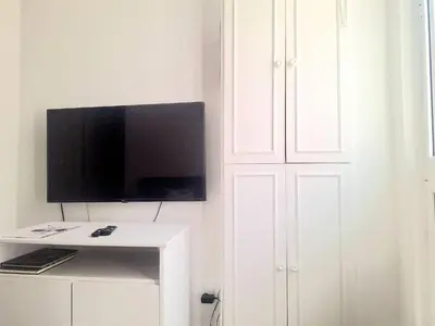 a white cabinet with a flat screen tv on top of it at porto true confession in Porto