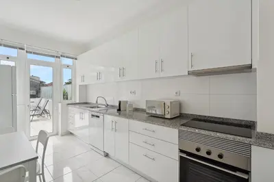 a white kitchen with white appliances and a patio at GuestReady - An elegant stay in the city centre in Porto