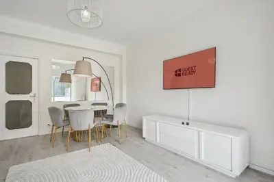 a white dining room with a table and chairs at GuestReady - An elegant stay in the city centre in Porto