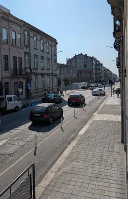 a city street with cars parked on the road at Riko Guesthouse in Porto