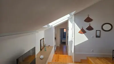 a room with white walls and a staircase with a window at Fontainhas Sunny Rooftop with balcony in Porto