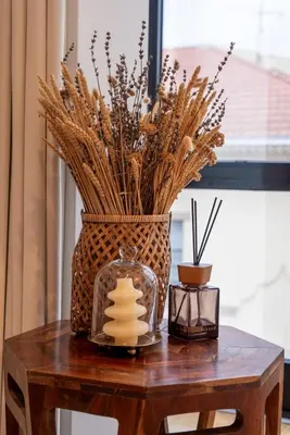 a table with a vase with dried grasses and a candle at Stylish Flat with Workspace & Garage by HostWise in Porto
