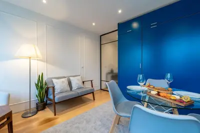 a living room with blue walls and a table and chairs at Stylish Flat with Workspace & Garage by HostWise in Porto
