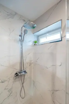 a shower in a bathroom with white marble at Stylish Flat with Workspace & Garage by HostWise in Porto