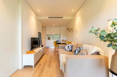 a living room with a couch and a kitchen at Studio w/ Balcony, Pool & Gym in Antas by HostWise in Porto