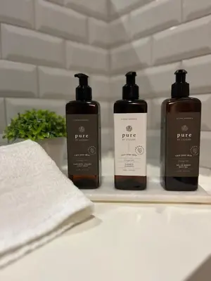three bottles of soap on a shelf in a bathroom at Avantgarde by Upperground in Porto