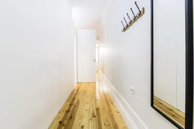 a hallway with a wooden floor and a mirror at Avantgarde by Upperground in Porto