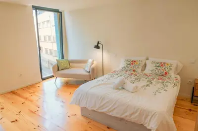 a bedroom with a bed and a chair and a window at Porto Breeze 2 in Porto
