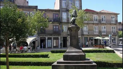 a statue in a park in front of a building at Ai Porto! Books&Roots in Porto