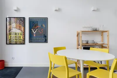 a dining room with a white table and yellow chairs at Cool Alegria Loft Mezzanine Retreat in Porto