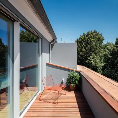 a deck with two chairs on a house at Baumhaus Serviced Living - Art & Design Apartments in Porto