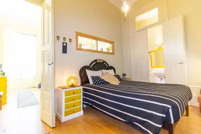 a bedroom with a bed with a black and white striped blanket at Ai Porto! Gold&Soul in Porto