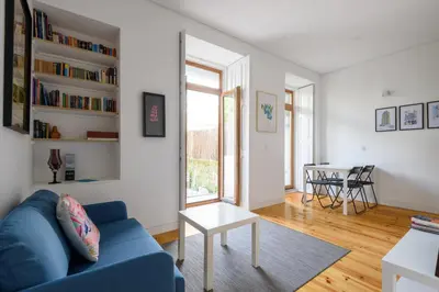 a living room with a blue couch and a table at Cool Alegria 1 Bed Studio Retreat in Bicas