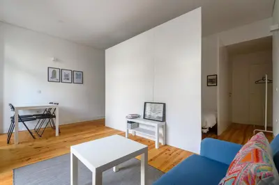 a living room with a blue couch and a table at Cool Alegria 1 Bed Studio Retreat in Bicas