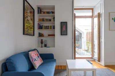 a living room with a blue couch and a table at Cool Alegria 1 Bed Studio Retreat in Bicas