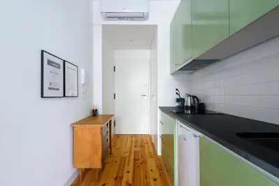 a kitchen with a black counter top and a wooden floor at Cool Alegria 1 Bed Studio Retreat in Bicas