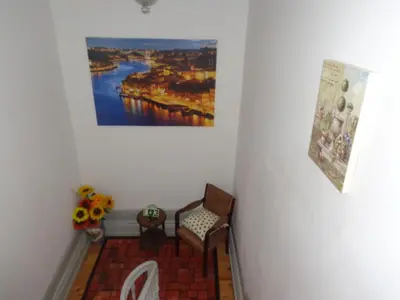 a hallway with a painting on the wall and a chair at Portuense Alojamento Local in Porto