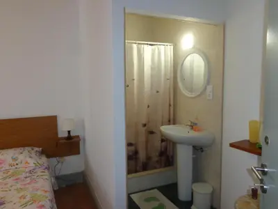 a bathroom with a sink and a shower with a mirror at Portuense Alojamento Local in Porto