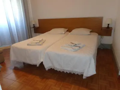 two beds in a room with white sheets and towels at Portuense Alojamento Local in Porto