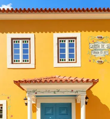 a yellow house with two windows and a door at Quinta de Sá in Vila Nova de Gaia