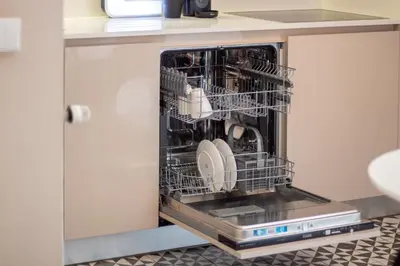 a dishwasher with dishes in it in a kitchen at Cardosas Bright Studio by LovelyStay in Porto
