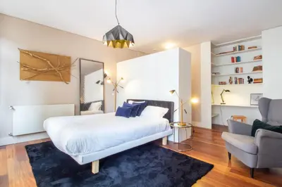 a bedroom with a large white bed and a chair at Cardosas Bright Studio by LovelyStay in Porto