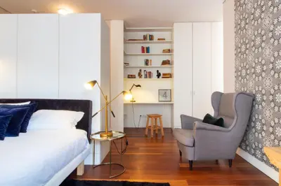 a bedroom with a bed and a chair at Cardosas Bright Studio by LovelyStay in Porto