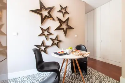a dining room with black chairs and a table with stars on the wall at Cardosas Bright Studio by LovelyStay in Porto