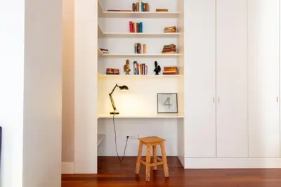 a stool and a lamp in a room with white walls at Cardosas Bright Studio by LovelyStay in Porto