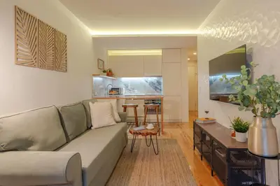 a living room with a couch and a kitchen at Lovely & Centre Flat with Terrace by HostWise in Porto
