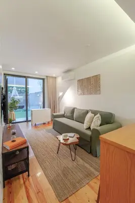 a living room with a green couch and a table at Lovely & Centre Flat with Terrace by HostWise in Porto