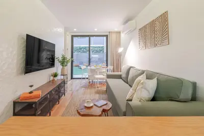 a living room with a green couch and a table at Lovely & Centre Flat with Terrace by HostWise in Porto