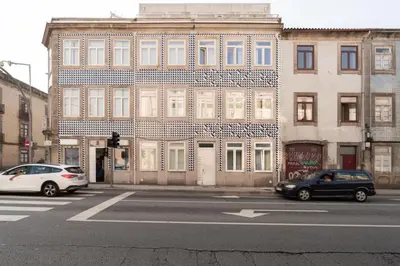 two cars are parked in front of a building at Lovely & Centre Flat with Terrace by HostWise in Porto